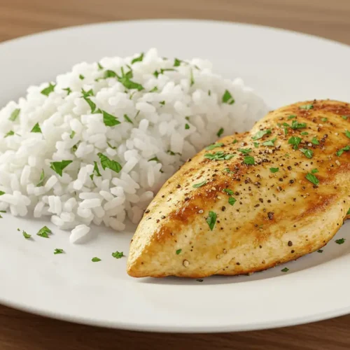 Putenschnitzel mit Reis: In 3 Schritten gesund & lecker Saftiges Putenschnitzel mit Reis und frischen Kräutern auf einem Teller.